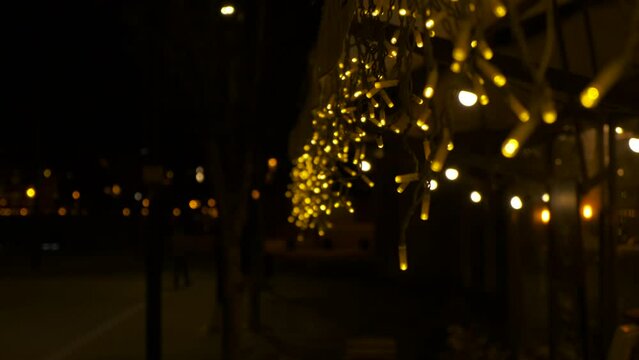 Street caffee facade in garlande. A bright decorative garlande on the caffee facade in the city during night time.