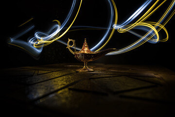 Antique Aladdin arabian nights genie style oil lamp with soft light white smoke, Dark background. - obrazy, fototapety, plakaty