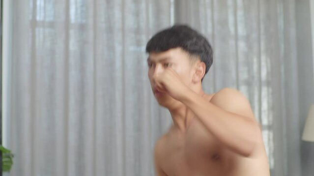 Close Up Of Asian Teenager Boy Boxing Warm Up While Doing Shirtless Workout At Home
