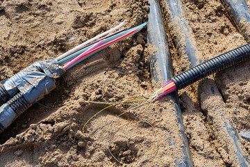 Disrupted during construction or repair work fiber optic cables for the internet lying in a trench.