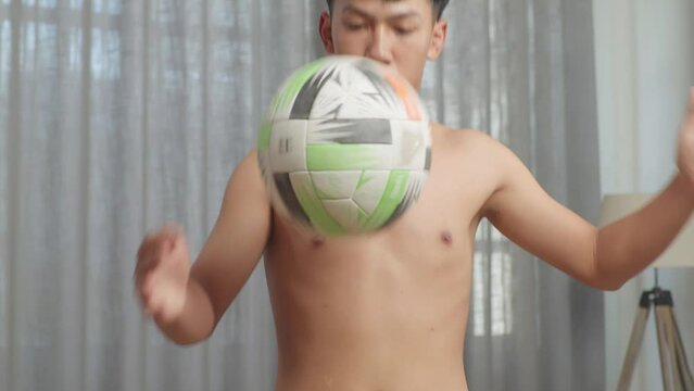 Close Up Of Asian Teenager Boy Doing Football Skills During The Shirtless Workout At Home
