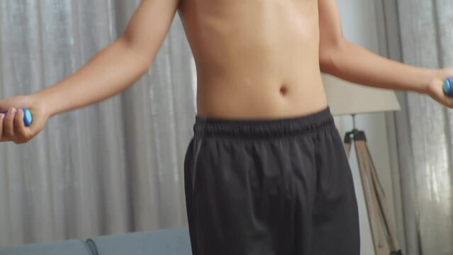 Close Up Of Asian Teenager Boy Jumps Rope Doing Shirtless Workout At Home

