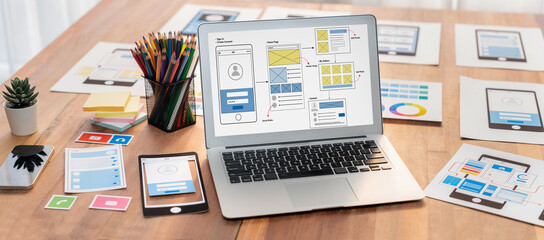 Digital and paper wireframe designs for web or mobile app UI UX display on laptop computer screen....