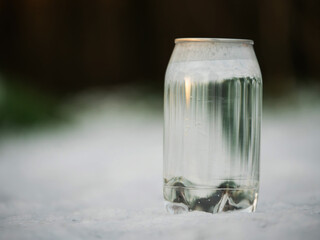 Bottle of clean bottle with water on a snow surface. Healthy drink in cold winter season.