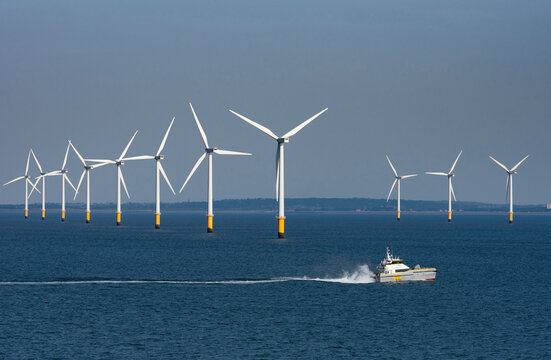 Burbo Bank, Liverpool Bay, England UK.  8 June 2023.  Viewed from the sea turbines on Burbo wind farm off the UK coast. Supply vessel HST Brixham underway passing turbines.