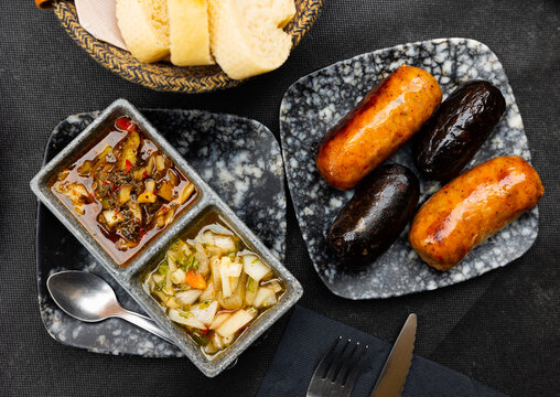 Delicious Uruguayan parrillas of chorizo and morcilla sausages served with spicy vegetable salsa criolla of tomatoes, onion and herbs..