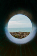 beach seen through round object 