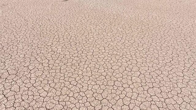 Aerial shot looking down at the cracked surface of a dry lake in Navada