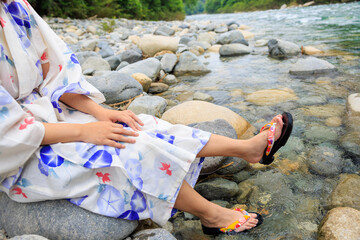 川に浸かる浴衣を着た女性の足