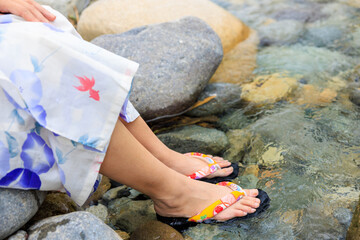 川に浸かる浴衣を着た女性の足
