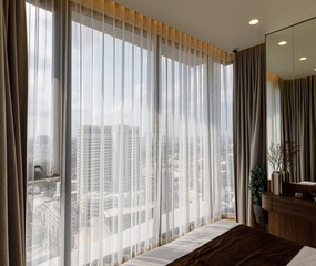Transparent white curtain tulle from an open window.  the sun's rays sunlight penetrate the room.