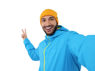Smiling young man taking selfie and showing peace sign on white background