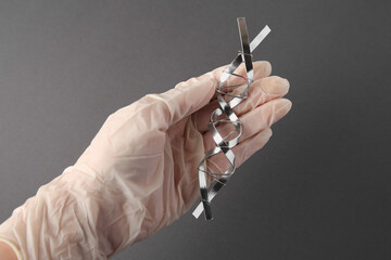 Scientist with DNA molecular chain model made of metal on grey background, closeup