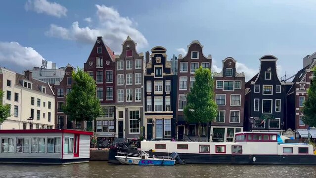 Traditional old narrow houses boats and canals Amsterdam, Netherlands, Europe, July 5 2023 . High quality 4k footage