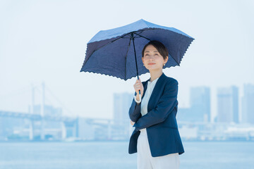日傘をさすビジネスウーマン（紫外線・日焼け対策）