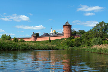 Naklejka na ściany i meble View of the Spaso-Evfimiev Monastery (a monastery of the Vladimir Diocese of the Russian Orthodox Church) on the bank of the Kamenka River on a sunny summer day, Suzdal, Vladimir region, Russia