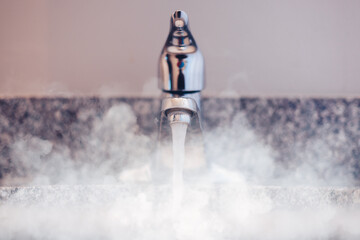 bathroom sink with chrome faucet and steam rising