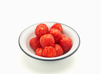 A pile of rotten tomatoes is on a bowl over a white background.
