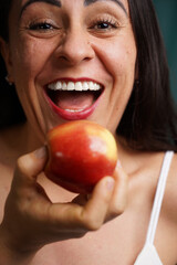smiling latin woman eating an apple, apple concept