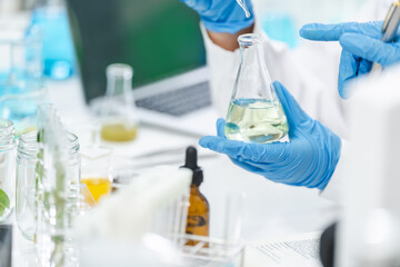 Fototapeta premium eco skin care beauty products in laboratory development concept, Natural drug research with organic plants and scientific extraction in glassware, Alternative green herb medicine for body health care
