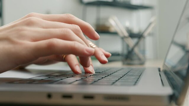 Close up of woman freelancer working on laptop at home office. Businesswoman writing business letter at work. Slow motion shot fingers typing on keyboard. Female hands closing computer with one hand