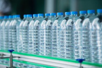 Drinking water plant. Selective focus water bottles on production line of factory. Process of filling water into plastic bottles to bring out to consumers