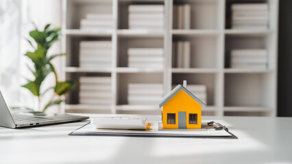 Real estate house toy model on  wooden table for display ads. Property investment concept