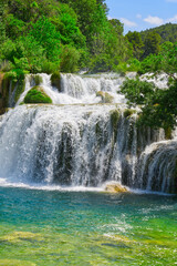 Fototapeta na wymiar Beautiful Waterfall background in sunny summer day. Beautiful Waterfall In Krka National Park - Croatia, Europe. Krka river waterfalls in the Krka National Park