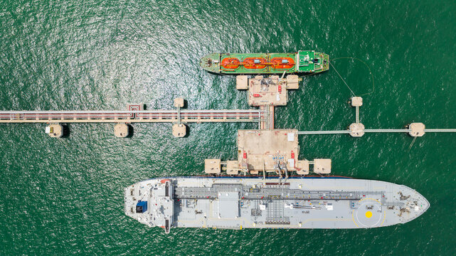 crude oil floating station in sea, bridge pipeline load unloading crude oil from oil ship transport, industry business transportation by container ship open sea,