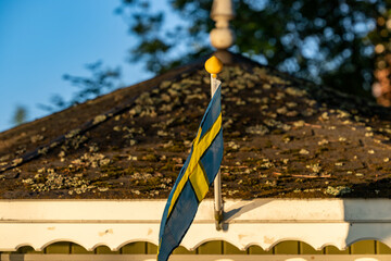 Stockholm, Sweden A small Swedish flag blows in the wind over the door of a garden terrace.
