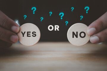 Man holding two wooden blocks with yes or no written on them