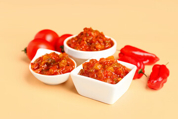 Composition with bowls of salsa sauce, bell peppers and tomatoes on color background