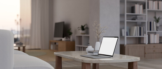 Close-up image of a laptop on a coffee table in a modern contemporary living room.