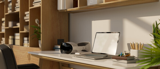 Close-up image of a modern home workspace with a laptop computer, a modern VR headset