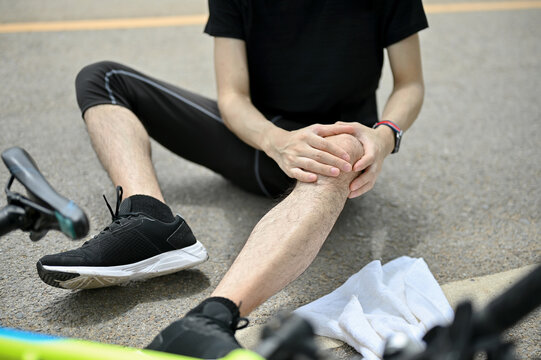 Close-up image of an injured male cyclist fell off the bike while biking along country roads.
