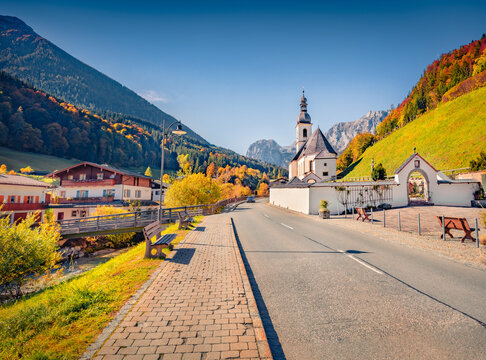 Beautiful autumn scenery. Superb morning scene of Parish Church of St. Sebastian. Colorful autumn view of Bavarian Alps, Ramsau village with asphalt road, Germany, Europe.