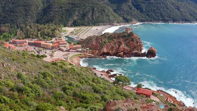4k drone forward video (Ultra High Definition) of Porto town with Genoise de Porto Ota tower. Aerial spring view of Corsica island, France, Europe. Traveling concept background..