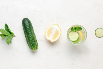 Glass of lemonade with cucumber and mint on white background