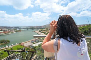 Fototapeta na wymiar A woman looking into binoculars on a viewpoint in Istanbul, Turkey