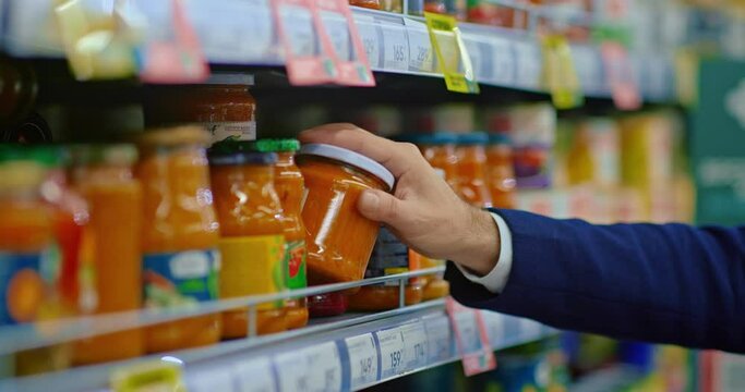 man taking jar with sauce for pasta from supermarket shelf, closeup of hand, 4K, Prores
