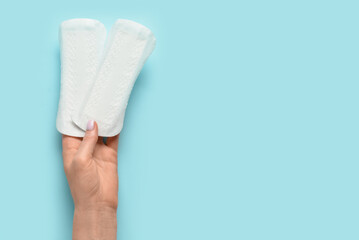 Woman with menstrual pads on blue background