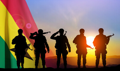 Silhouettes of a soldiers with Ghana flag against the sunset. EPS10 vector