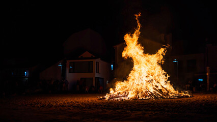 rural celebration with the hole town watching the fire of a bonfire