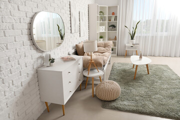 Interior of light living room with mirror, chest of drawers and soft carpet