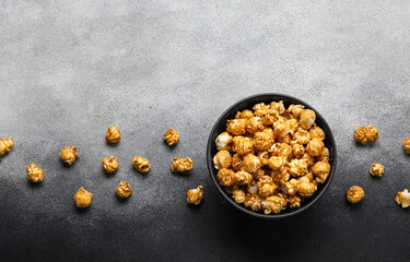 Bowl with tasty popcorn on grey background
