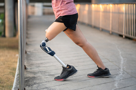 Low angle exercise woman with prosthetic leg and stretching in the park