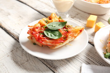 Plate of pasta with tomato sauce and cheese on white wooden background