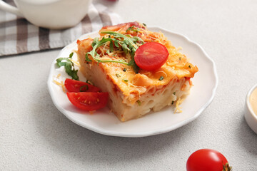 Plate of pasta with tomato sauce and cheese on grey background