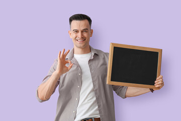 Male teacher with chalkboard showing OK on lilac background