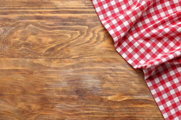 Red checkered napkin on wooden background